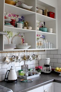 a kitchen counter with dishes and cups on it