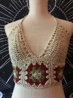 a crocheted top with red and green flowers on it