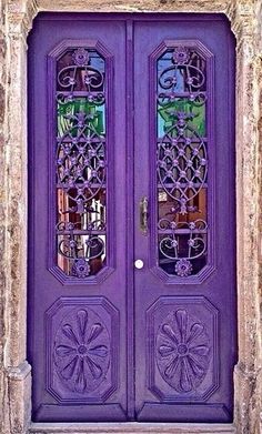 a purple door with ornate iron work on it