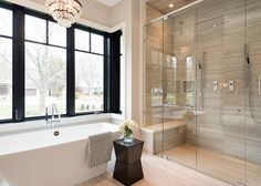 a bathroom with a tub, shower and large windows