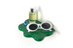 a green tray with sunglasses and a bottle on the top that is shaped like a frog