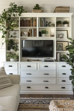 a living room with white furniture and bookshelves filled with plants on top of them