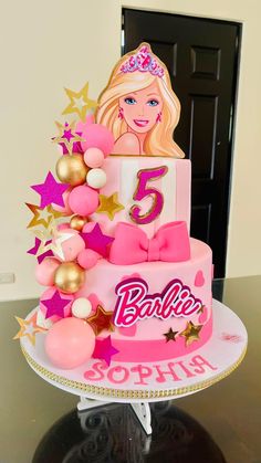 a barbie birthday cake with pink and gold decorations