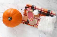 an orange pumpkin sitting on top of a table next to a pair of slippers