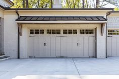 a white garage with two doors and windows