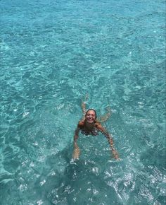 a woman is swimming in the clear blue water