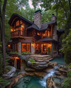 a large log home with a waterfall in the front yard and windows on each side