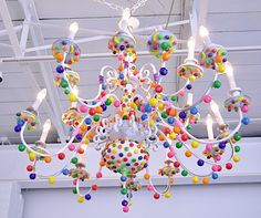 a multicolored chandelier hanging from the ceiling in a room with white walls