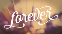 the word forever written in cursive writing on a blurry background with sunbeams