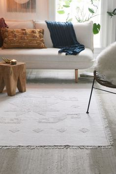 a living room filled with furniture and a white rug