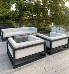 an outdoor furniture set on a deck with trees in the background