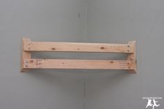 a wooden shelf mounted to the side of a wall