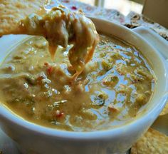 a person dipping some crackers into a bowl of soup