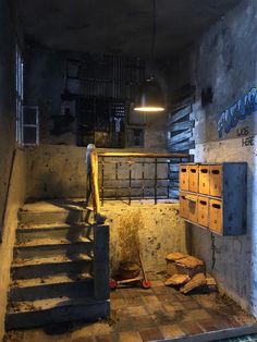 an abandoned building with stairs leading up to the basement and storage boxes on the floor