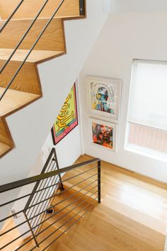 there is a staircase with pictures on the wall and wood flooring in this room