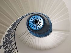 a spiral staircase with a blue skylight in the center