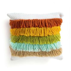 a multicolored pillow with fringes on the front and back of it, against a white background