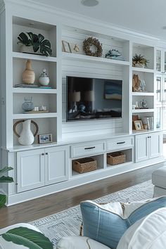 a living room filled with furniture and a flat screen tv on top of a white entertainment center