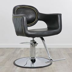 a black leather chair with chrome base and foot rest in front of a white wall