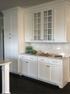 a kitchen with white cabinets and black floors