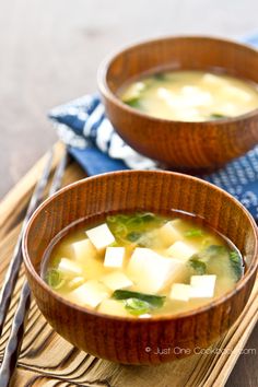 two wooden bowls filled with soup on top of a table