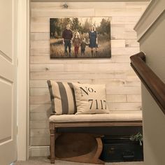 an entry way with a bench and pictures on the wall