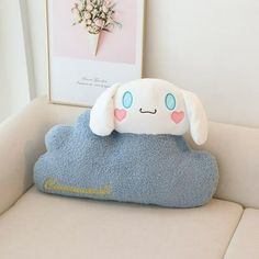 a stuffed animal sitting on top of a blue cloud pillow next to a white wall