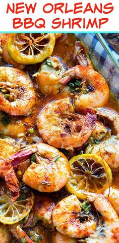 a dish with shrimp, tomatoes and lemons on it in a glass casserole