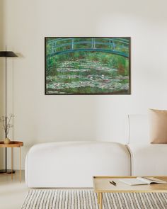 a living room filled with furniture and a painting hanging on the wall over a white couch