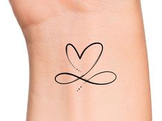 a small tattoo on the wrist with a heart and an arrow in it's center