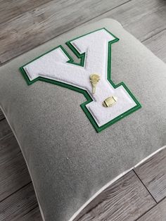 a pillow with the letter y on it and a pair of gold earring clips