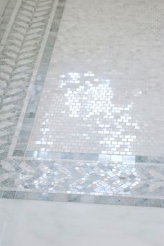 a bathroom with a marble floor and white tile on the shower wall is pictured in this image