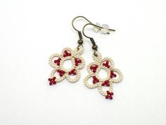 These cute flower earrings feature cream thread and red beads. The lace dangles from bronze tone ear wires which are nickel free.  These cute, light weight earrings are perfect for everyday wear. Earrings are handmade shuttle tatted lace created using 100% cotton thread. Glass seed beads are used to accent the design.  Simple and lightweight earrings. Wear them to your next causal gathering.  Earrings include clear ear stops and come packaged in a jewelry gift box. Flora pattern by Elizabeth ... Handmade Beige Flower Earrings For Gift, Handmade Cream Flower Earrings For Gift, Handmade Beige Flower Earrings As Gift, Handmade Cream Flower Earrings, Handmade Cream Beaded Earrings Gift, 40s Hollywood, Red Beaded Earrings, Hollywood Starlet, Flora Pattern