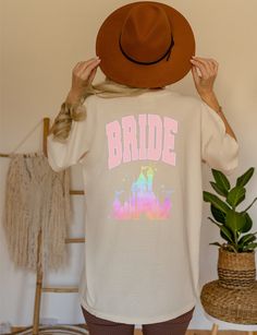 the back of a woman wearing a bridal t - shirt and brown cowboy hat