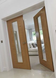 an open door leading to a living room with a white couch in the back ground