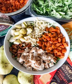 several different types of food are in bowls on a table with apples and other foods