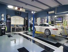 a white car is being worked on in a garage with blue walls and black and white checkered flooring