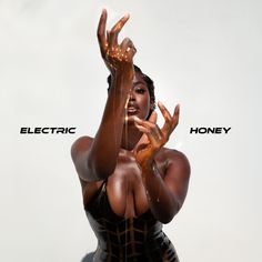 a woman in latex holding her hands up to the side with electric honey written on it