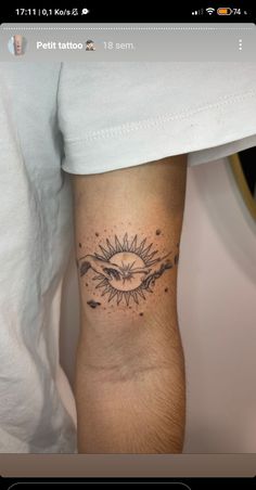 a person with a tattoo on their arm and the sun in the sky behind them