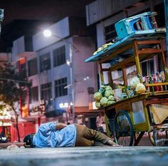 a man laying on the ground next to a cart