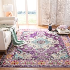 a living room area with a purple rug and white couches in front of a window