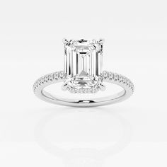 an emerald cut diamond ring with diamonds on the band