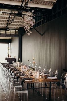 a long table is set with clear chairs