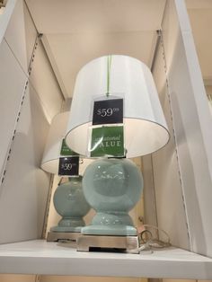 a lamp that is sitting on top of a shelf in a store with price tags