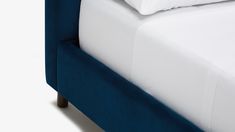 a close up of a bed with white sheets and blue headboard, on a white background