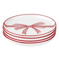 three red and white plates stacked on top of each other, with a bow design