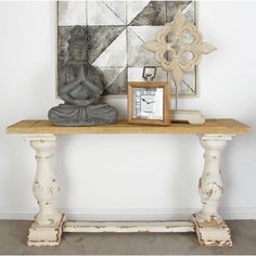 a wooden table topped with a clock next to a painting