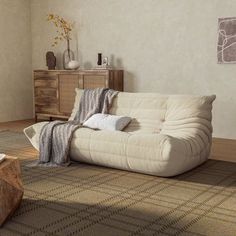 a living room with a white couch and coffee table on the floor next to it