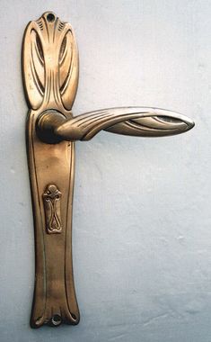 an ornate brass door handle on a white wall