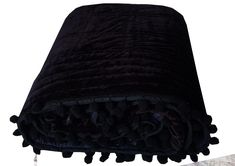 a black blanket with pom poms on it